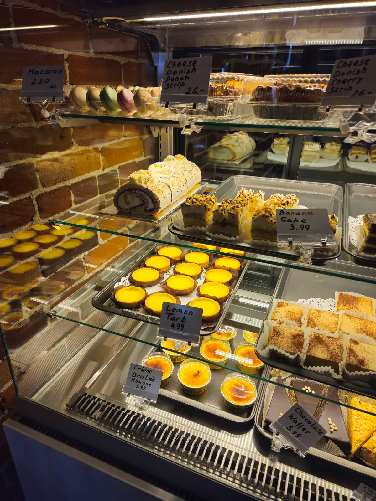 Macarons, lemon tarts and creme brulee mousse in the case